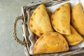 Home Baked Empanadas Turnover Pies with Pisto Vegetable Cheese Filling in Tomato Sauce in Wicker Basket. Spanish Pastry Dark Table Royalty Free Stock Photo