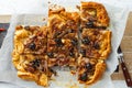 Home baked onion pie with anchovy and black olives cut into pieces on white background , closeup view