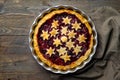 Home baked puff pastry Christmas tart with plum cinnamon jam filling decorated with stars. Dark wooden table linen kitchen towel Royalty Free Stock Photo
