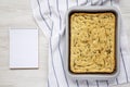 Home-baked Rosemary Garlic Focaccia Bread, blank notepad on a white wooden background, top view. Flat lay, overhead, from above