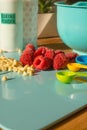 Home Baking Ingredients Including White Chocolate Chips and Raspberries and Colorful Measuring Spoons Royalty Free Stock Photo