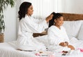 Home Beauty Salon. Loving Black Mom Braiding Hair To Her Little Daughter