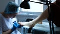 Home beauty salon - pedicurist applies a transparent fixative gel polish on toenails, camera movement