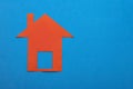 Home buying and selling concept - Red paper house on blue color background Royalty Free Stock Photo