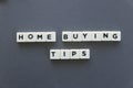 Home buying tips word made of square letter word on grey background.