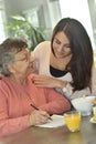 Home carer helping an elderly lady with crosswords