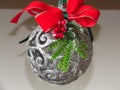 Home Christmas decoration. A silver ball. small green Christmas tree branch, red ribbon and mistletoe on light blurred background. Royalty Free Stock Photo