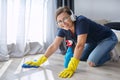 Home cleaning on positive, woman in headphones gloves cleans floor