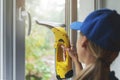 Home cleaning service - worker washing window with vacuum cleaner