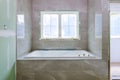 Home construction bathtub tiled walls after installing remodeling master bathroom patching drywall Royalty Free Stock Photo