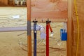 Home construction with hot and cold blue and red pex pipe layout in pipes new bathtub house PVC waste water system Royalty Free Stock Photo