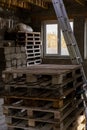Home construction. Room with building materials, wooden pallets, stairs, concrete wall blocks, window, vertical frame
