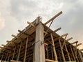 Home construction with wooden scaffolding from bottom view under cloudy sky Royalty Free Stock Photo