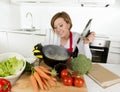 Home cook woman in red apron at domestic kitchen holding cooking pot with hot soup smelling vegetable stew Royalty Free Stock Photo