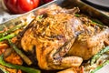 Home cooked roasted chicken with vegetables carrots, sweet potatoes, asparagus in baking form, tomatoes Royalty Free Stock Photo