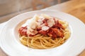 Home cooked spaghetti with a tomato, bacon and garlic sauce, with added parmesan cheese flakes. The steam from the hot food can be