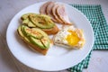 Home cooking breakfast with avocado toast, fried egg and ham on white plate Royalty Free Stock Photo