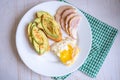 Home cooking breakfast with avocado toast, fried egg and ham on white plate Royalty Free Stock Photo