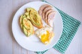 Home cooking breakfast with avocado toast, fried egg and ham on white plate Royalty Free Stock Photo