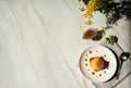 Delicious rice pudding with pumpkin, caramel sauce and yellow forsythia flowers on a background of pastel green marble.