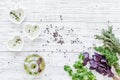 Home cooking with fresh greenery and organic oil on light wooden table background top view mock up