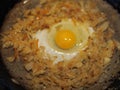 Home cooking. Fried cabbage, egg in a black pan over a fire. A bachelor breakfast is being prepared Royalty Free Stock Photo