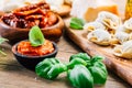 Home cooking - raw tortellini pasta with tomato pesto and sun-dried tomatoes and basil Royalty Free Stock Photo
