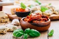 Home cooking - raw tortellini pasta with tomato pesto and sun-dried tomatoes and basil Royalty Free Stock Photo