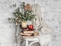 Home cozy still life - an old vintage chair, stack of books, knitted plaid, candle, apple fruit. Hobby, leisure, comfort concept. Royalty Free Stock Photo