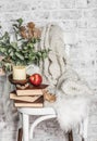 Home cozy still life - an old vintage chair, stack of books, knitted plaid, candle, apple fruit. Hobby, leisure, comfort concept. Royalty Free Stock Photo