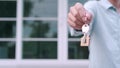 Home dealer offers a key for a new home. The owner of the house is showing the key to possessing the house. New house trading conc