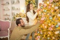 Young happy couple decorating christmas tree together Royalty Free Stock Photo