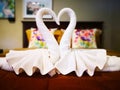 Home decoration concept. White towels were folded into two swans, kissing each other, causing a heart-shaped space. It is located Royalty Free Stock Photo