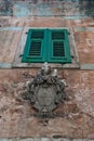 Heraldic sign under the window with green shutters