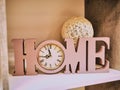 Home decoration of letters Home, Clock and a bowl of wicker from a vine. Beautiful writing home with clock instead of letters o, H