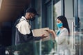 Home deliveries made safer with smart technology. a masked young man and woman using smartphones during a home delivery. Royalty Free Stock Photo