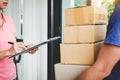 Home delivery service and working with service mind, Woman customer signing and receiving a cardboard boxes parcel from Royalty Free Stock Photo