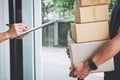 Home delivery service and working with service mind, Woman customer signing and receiving a cardboard boxes parcel from Royalty Free Stock Photo