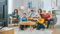 At Home Diverse Group Friends Watching TV Together, Eating Snacks and Drinking Beverage. They Prob Royalty Free Stock Photo