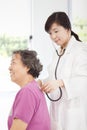 Home doctor measuring senior woman blood pressure