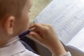 Home education. Home work after school. Boy with pen writing english words by hand on traditional white notepad paper. Royalty Free Stock Photo