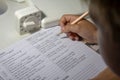 Home education. Home work after school. Boy with pen writing english test by hand on traditional white notepad paper. Royalty Free Stock Photo