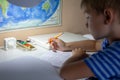 Home education. Home work after school. Boy with pen writing english test by hand on traditional white notepad paper. Royalty Free Stock Photo