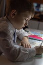 Home education. Home work after school. Boy with pen writing english words by hand on traditional white notepad paper. Royalty Free Stock Photo