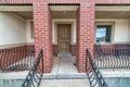 Home entrance with brown front door and metal furniture at the elevated porch Royalty Free Stock Photo