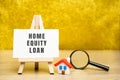 Home equity loan concept. Type of loan in which the borrowers use the equity of their home as collateral. Easel, house and