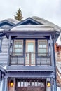 Home exterior with snowy gable roof over balcony and glass paned garage door. Royalty Free Stock Photo