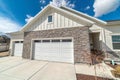 Home facade with two car attached garage gable roof and stone exterior wall Royalty Free Stock Photo