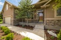 Home facade with view of yard garage door porch and front door on a sunny day