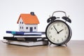 Home finance concept with ticking clock and books
